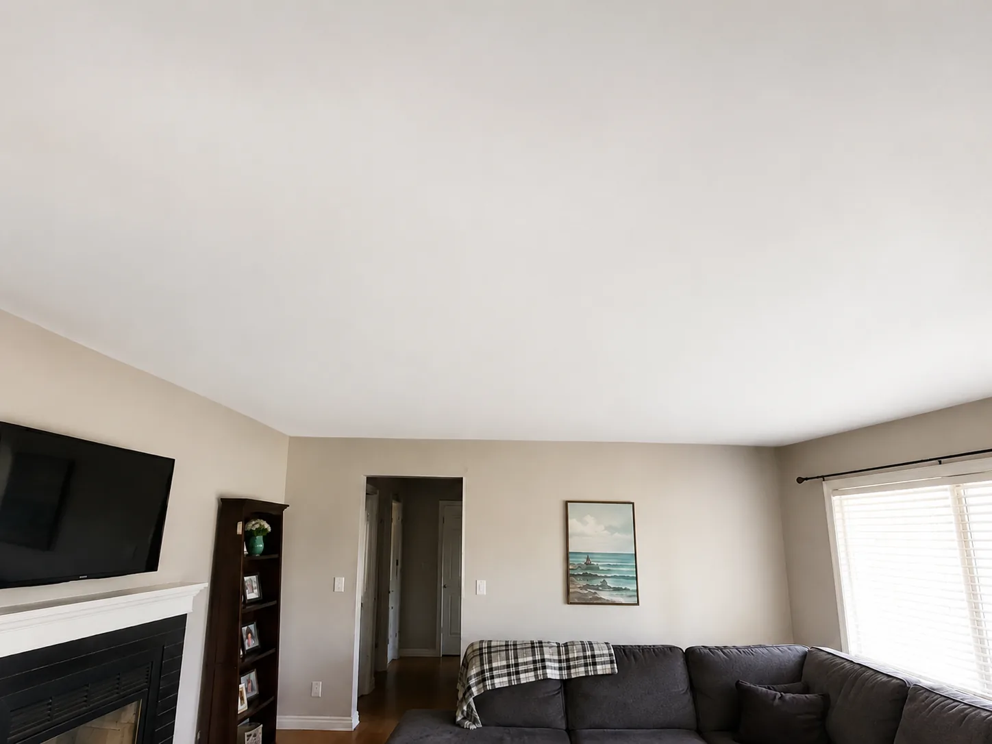 Living room ceiling after water-damage repair and smooth white refinishing