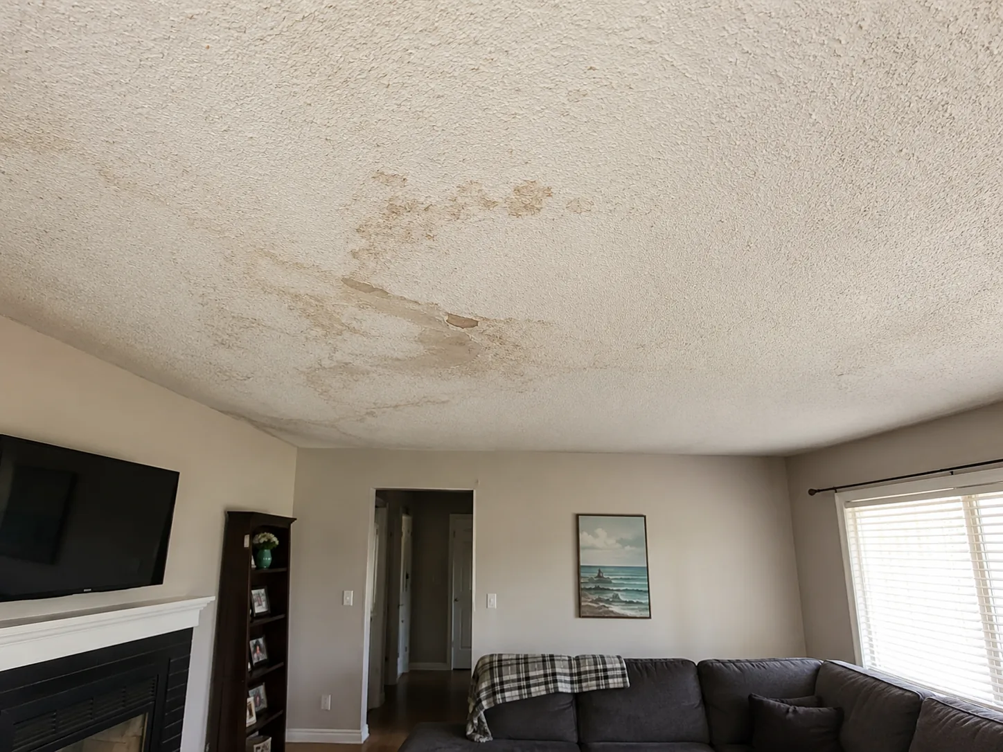 Water-stained popcorn ceiling before professional repair and texture removal
